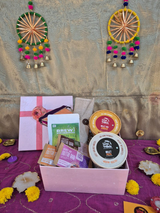 Gift box with brewed Green Tea , and pink packaging on purple fabric.
