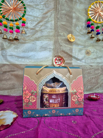 Gift box featuring Millet Upma tin with traditional Indian festive decorations.