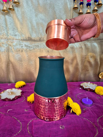A dark teal and copper-toned metal decorative vessel Opening Lid And Pouring water in it.